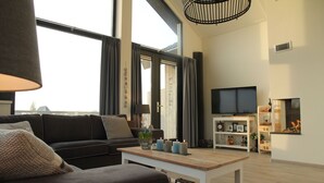 Una sala de estar moderna con sofá, mesa de centro y televisión.