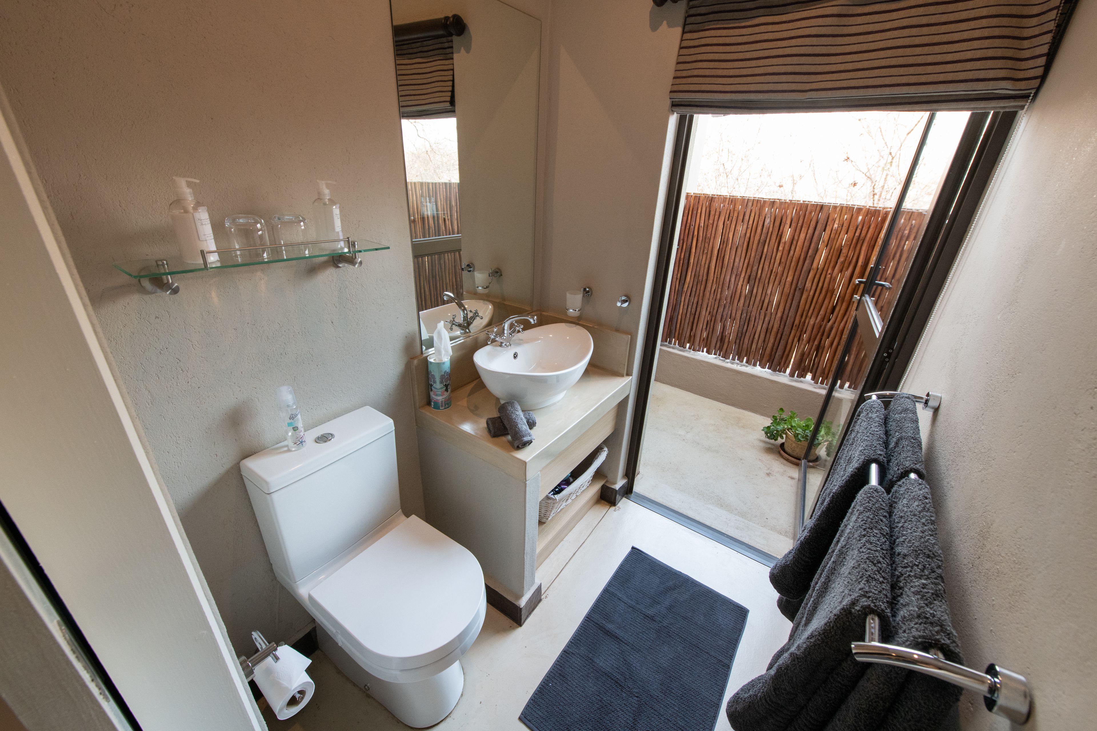 Un baño con inodoro, lavamanos y zona de ducha.