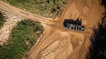 An aerial view of a desert campsite with a tent and a vehicle.