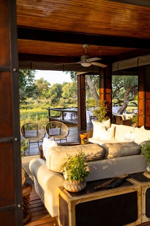 An outdoor seating area with a wooden deck, wicker chairs, a sofa, and a table. - Karongwe - Becks Safari Lodge (Hoedspruit)