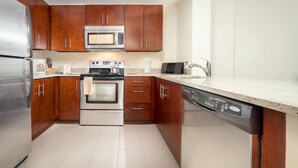 A modern kitchen with wooden cabinets, stainless steel appliances, and a dishwasher.