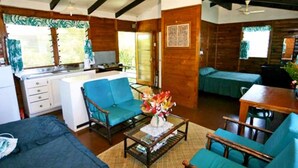 Um quarto aconchegante em estilo cabana, com cozinha compacta, sala de jantar e um quarto.