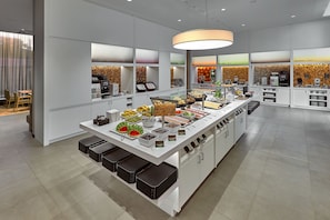 A modern breakfast bar with a variety of food options and a coffee station.