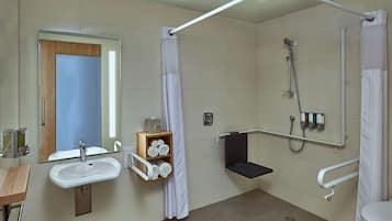 A modern bathroom with a sink, mirror, and shower.