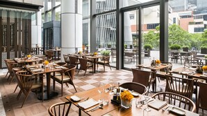 A spacious restaurant with high ceilings and large windows, offering a view of the cityscape. - Cordis Shanghai Hongqiao (Shanghai)