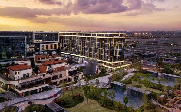 Un moderno complejo de edificios urbanos con varios pisos, ventanas amplias y una combinación de espacios comerciales y residenciales.