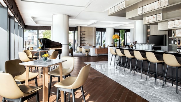 A modern interior with a piano, dining area, bar, and kitchen. - Cordis Shanghai Hongqiao (Shanghai)
