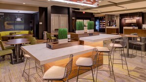 A modern hotel lobby with a bar area, seating arrangements, and a reception desk. - Courtyard by Marriott St. Louis Chesterfield (Chesterfield)