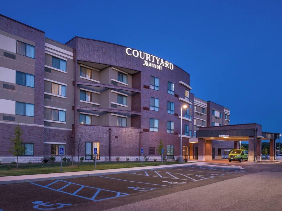A Courtyard Marriott hotel with a parking lot and a green shuttle service.