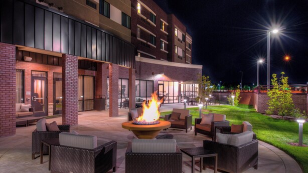 An outdoor patio area with wicker furniture and a central fire feature. - Courtyard by Marriott St. Louis Chesterfield (Chesterfield)
