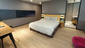Una habitación de hotel moderna con una cama grande, un escritorio y una silla.