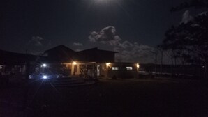 A house with a porch and a driveway at night. - Bluepango Guest House - Hostel (Port Vila)