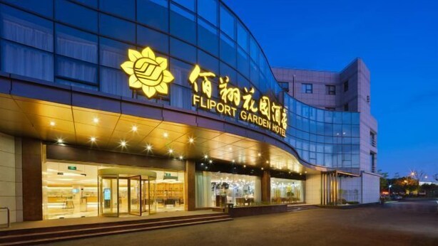 A modern hotel with a glass facade and illuminated signage.