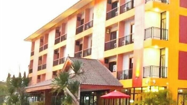 Een hotel met meerdere verdiepingen, balkons, een overdekte ingang en een terras.
