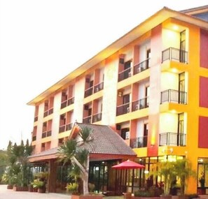 A multi-story hotel with balconies, a covered entrance, and outdoor seating area. - Tawan Anda Garden Hotel (Surat Thani)