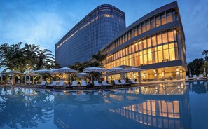 A modern hotel with a pool, lounge chairs, and umbrellas. - LOTTE Hotel Yangon (Yangon)