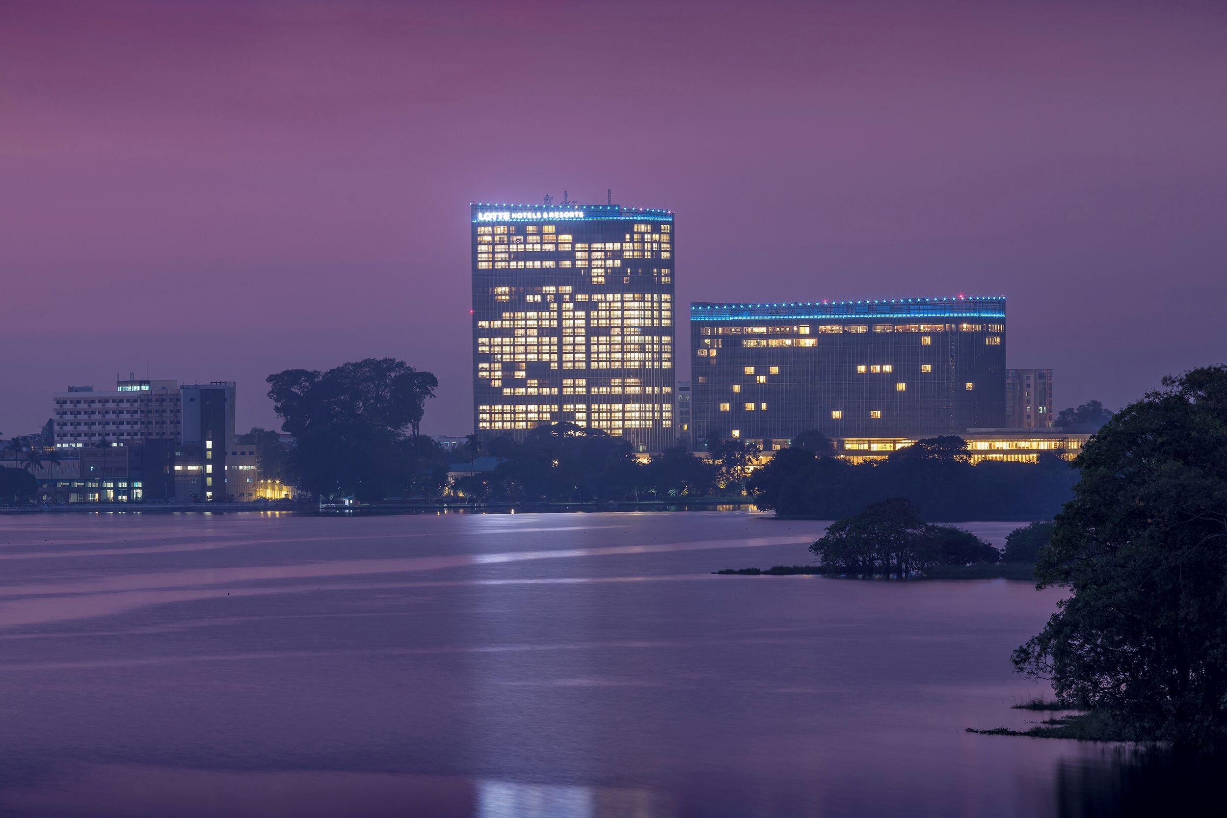 A high-rise hotel with illuminated windows and a modern architectural design.