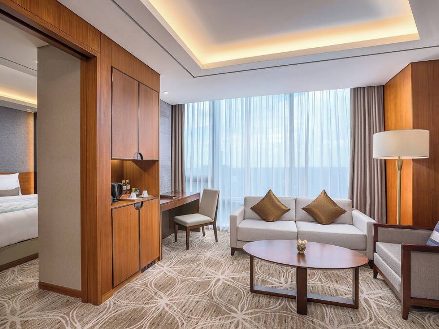 Una habitación de hotel con una cama, un sofá, un escritorio y una silla.