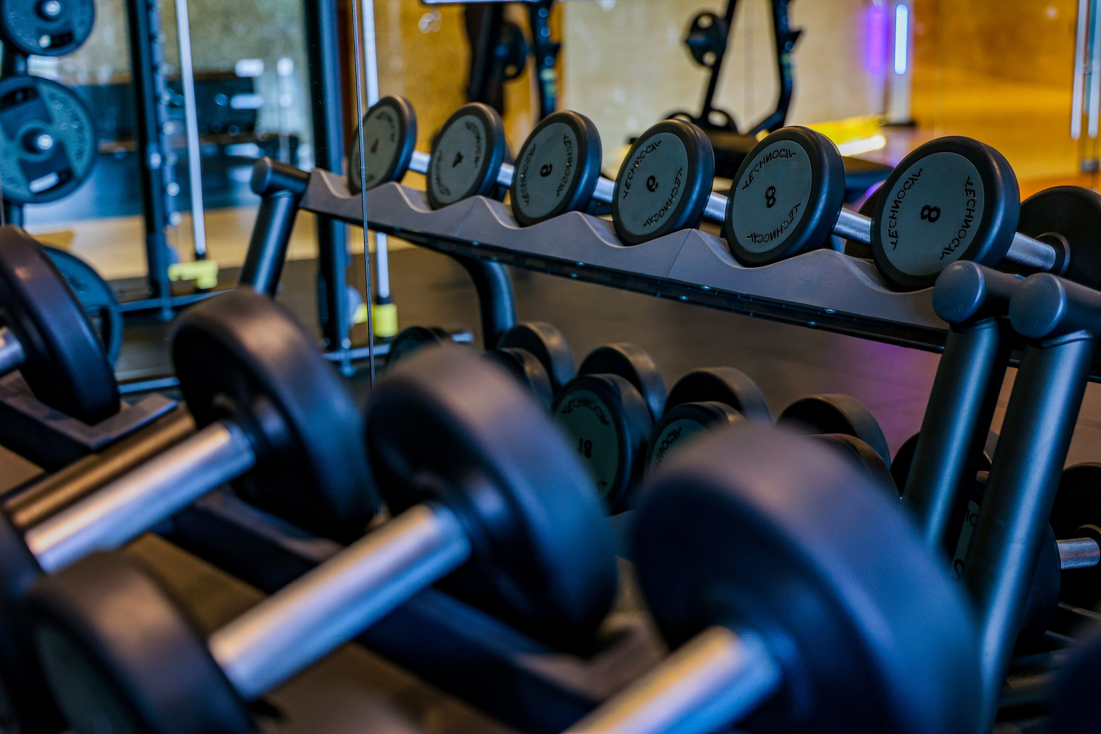 A rack of dumbbells with weight markings, indicating a gym setting.