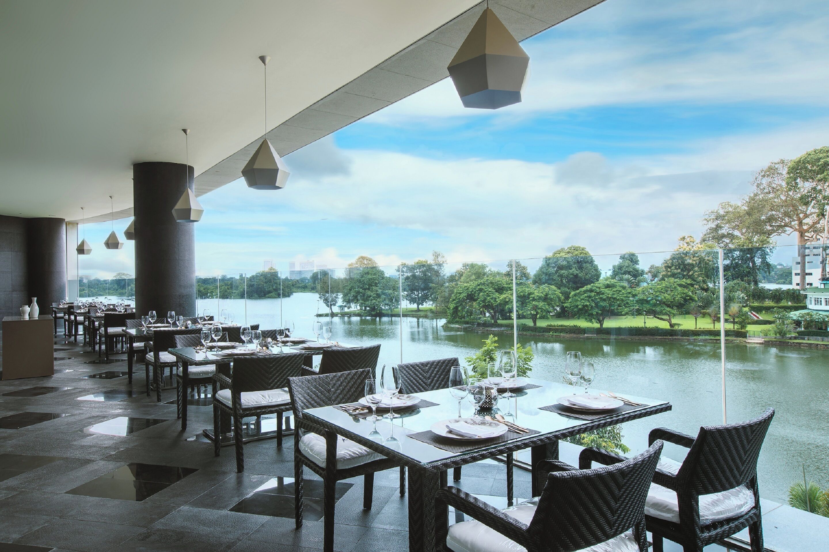 A restaurant with tables set for dining, overlooking a lake.
