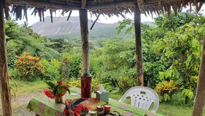 Mesa al aire libre con vista a un paisaje exuberante y montañas al fondo.