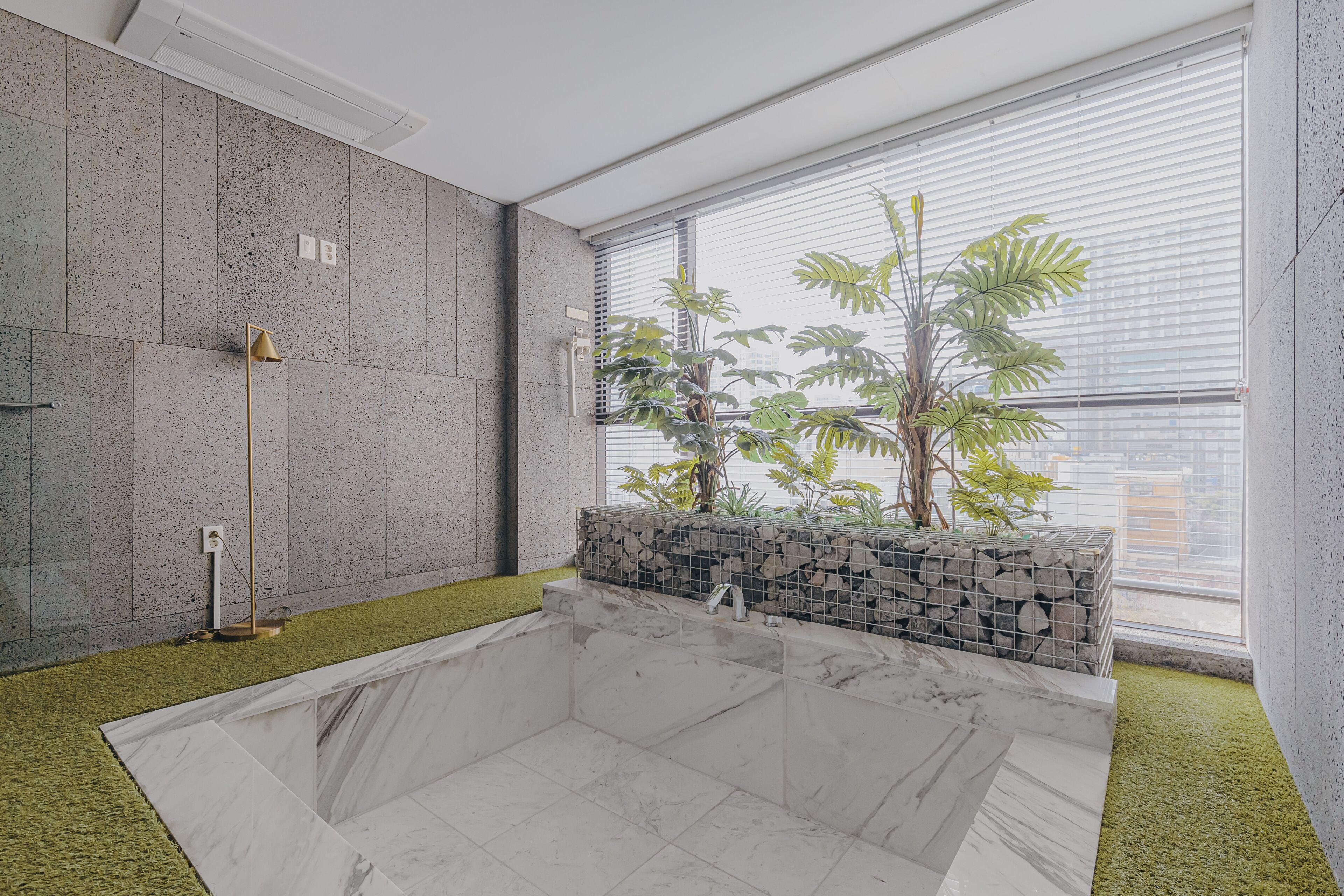 Un baño moderno con una bañera grande, zona de ducha y ventana con vistas a la ciudad.