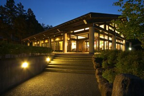 A modern building with a covered entrance, large windows, and steps leading up to the door. - Hotel Kikori (Hida)