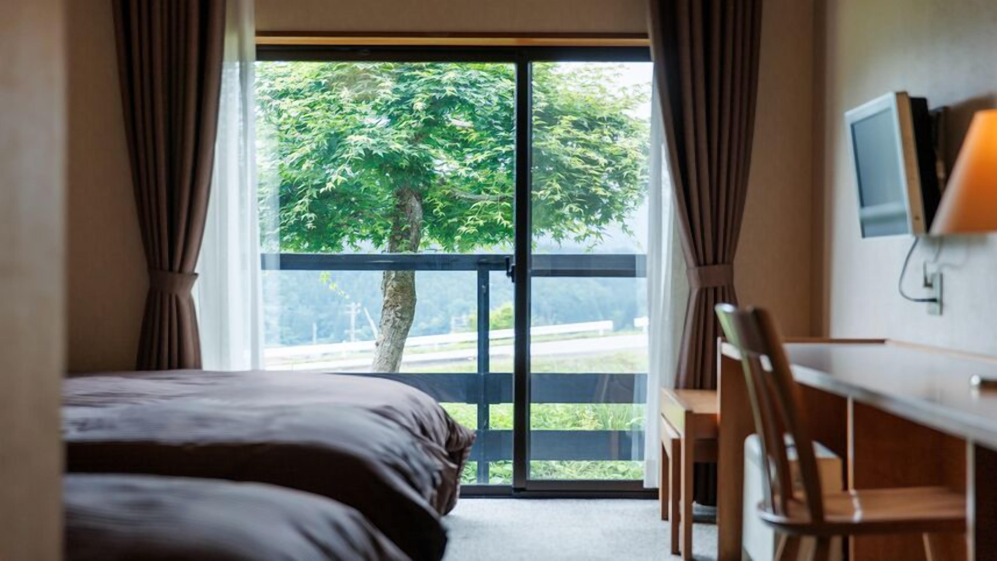 Un dormitorio con cama, escritorio y televisor.