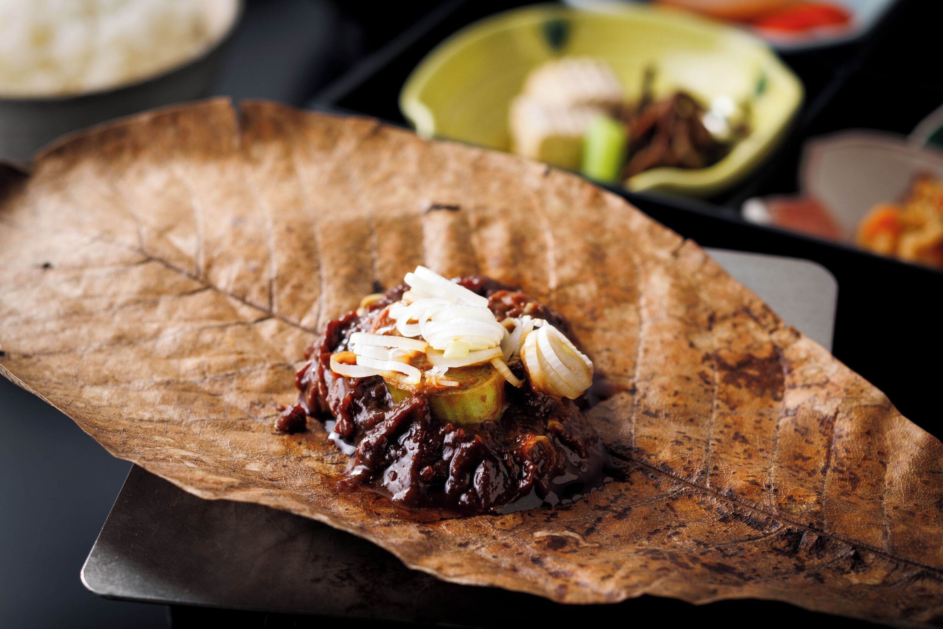 A dish served on a large, rustic leaf.