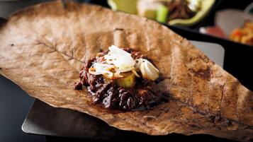 A dish served on a large, rustic leaf.