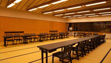A conference room with long tables and chairs, a podium, and a large window.