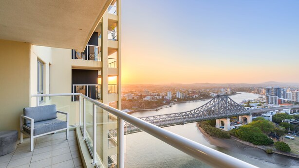 A balcony with a view of a cityscape, including a bridge and river.