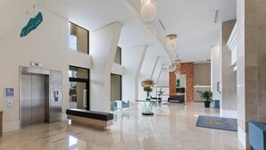 A modern lobby with a glass table, a reception desk, and a seating area.