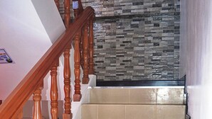 Un escalier avec des balustrades en bois et des carreaux de couleur beige.