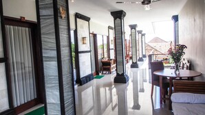 A spacious hallway with marble columns, a green mat at the entrance, and a view of the outside. - Lebak Bali Nelayan (Canggu)