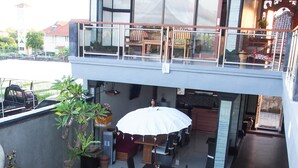 A modern house with a rooftop deck, a swimming pool, and outdoor furniture. - Lebak Bali Nelayan (Canggu)