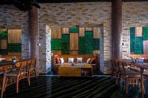 Um interior aconchegante com parede de tijolos, móveis de madeira e parede verde de destaque.