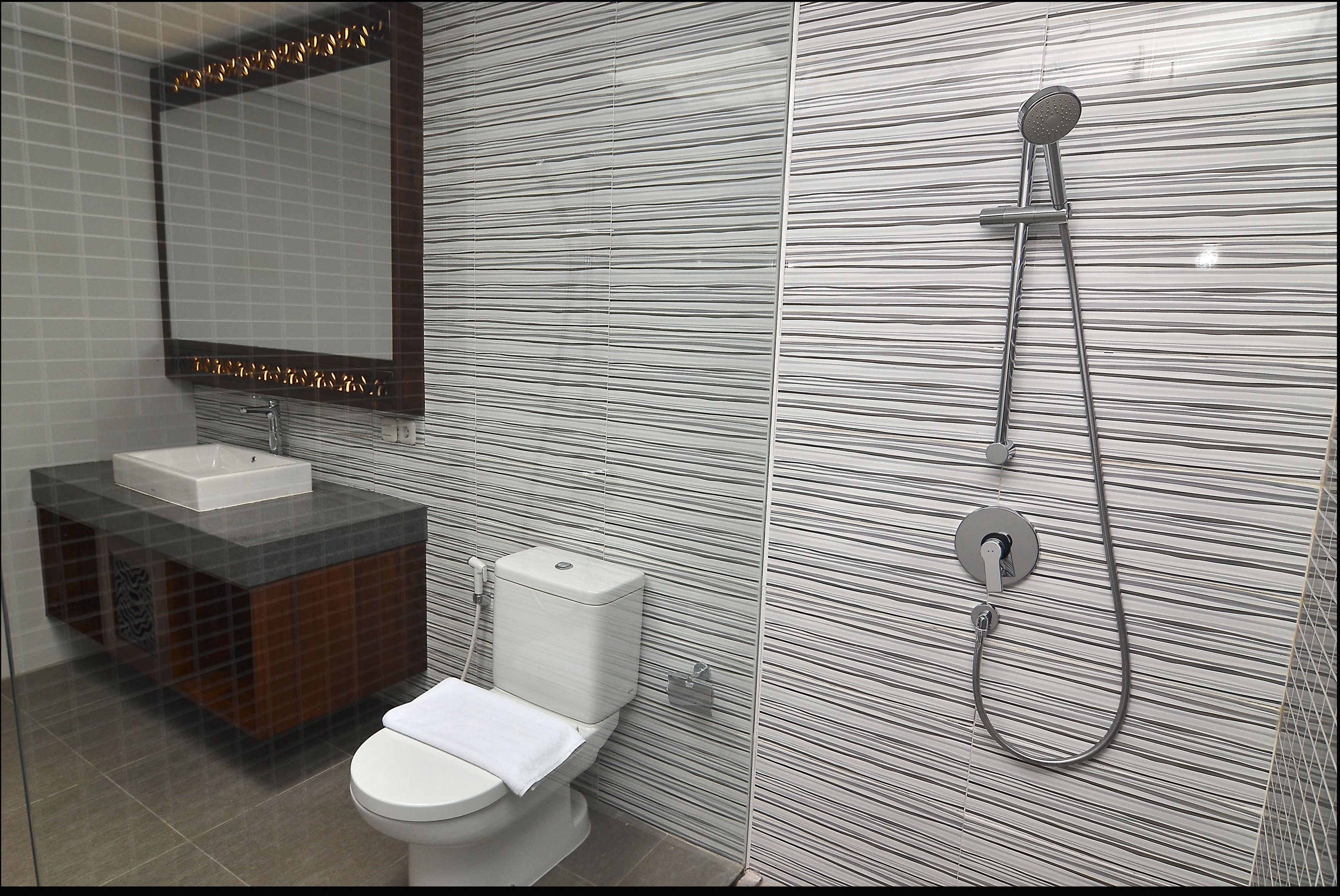 A modern bathroom with a glass-enclosed shower, a white toilet, and a vanity with a sink.