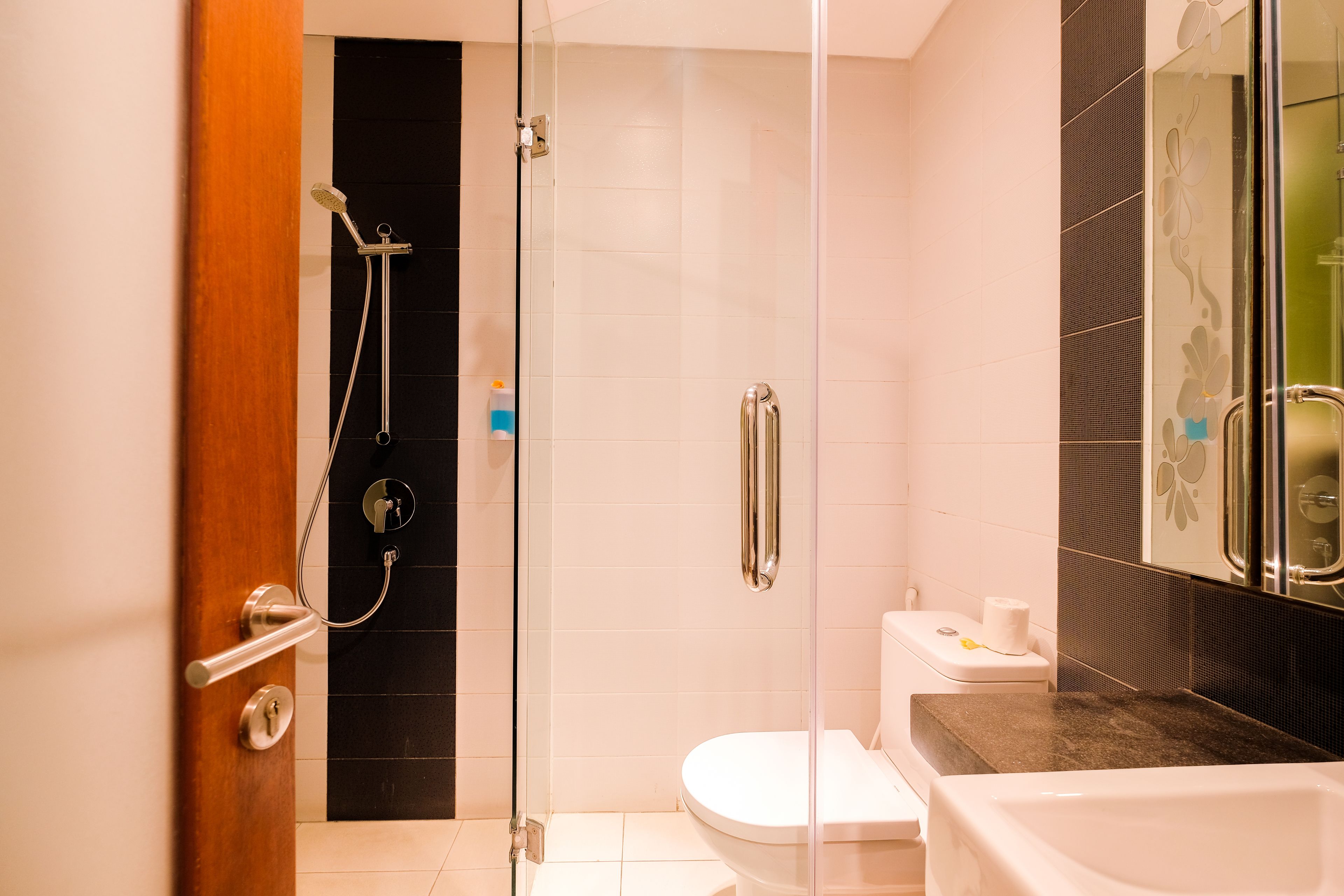 A modern bathroom with a glass shower enclosure, a white toilet, and a bathtub.