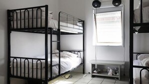 A dormitory room with bunk beds, a small desk, and a window with blinds. - Gonow Family Backpackers Hostel (West End)