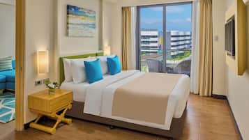 A hotel room with a large bed, a nightstand, a TV, and a view of a building through the window.