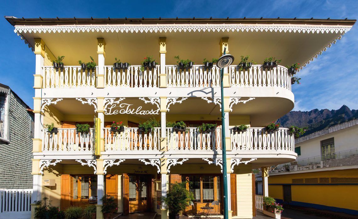 A multi-story building with balconies adorned with potted plants.