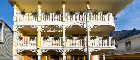 A multi-story building with balconies adorned with potted plants.