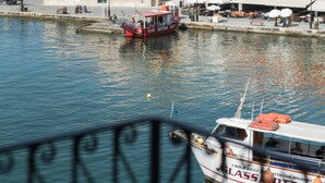 Une scène de bord de mer avec un bateau nommé « Glass Bottom » amarré près d’un bâtiment historique surmonté d’un dôme.