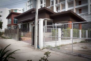 A multi-story residential building with a gated entrance and a covered porch.