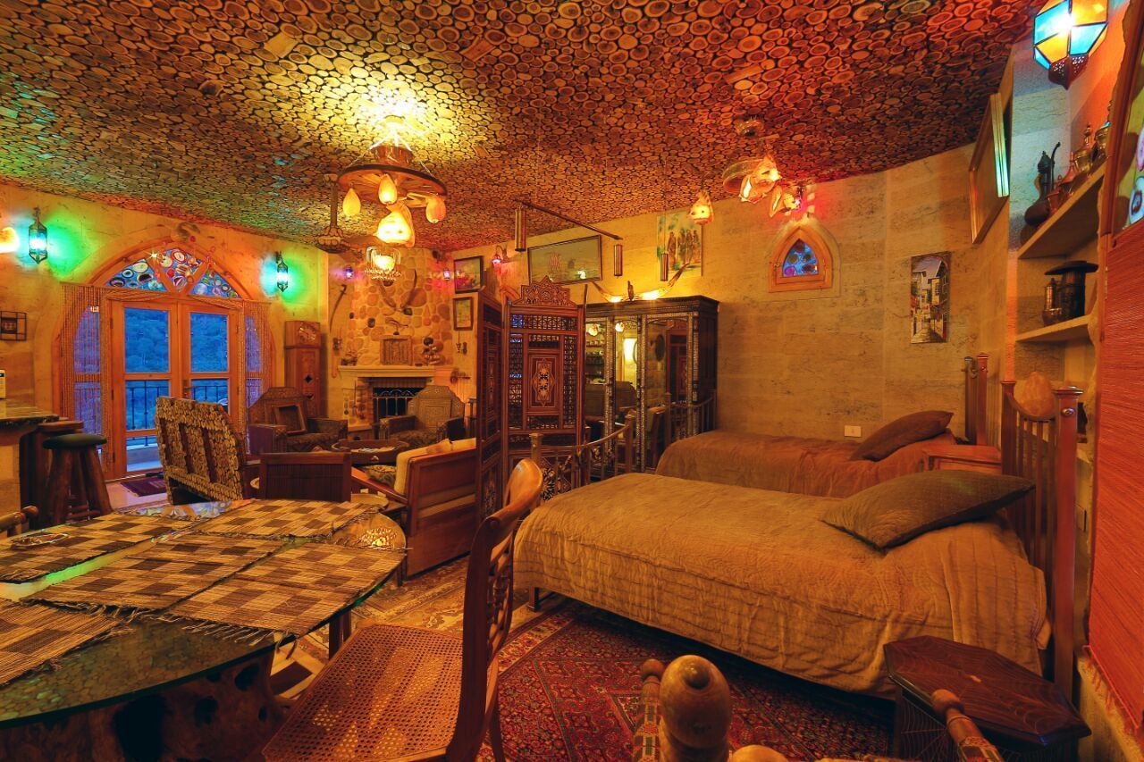 Une pièce confortable avec un grand lit, une table en bois et une cheminée.