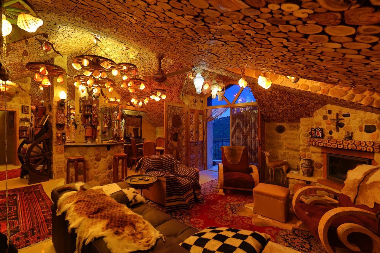 A cozy interior with stone walls, a fireplace, and a bar area.