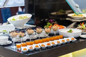 Un bufé con diversos platos y bebidas.