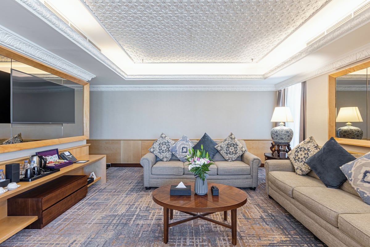 A modern living room with a sofa, coffee table, and a TV.