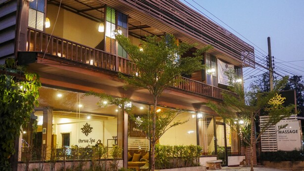 A spa with a balcony, a massage sign, and a well-lit entrance. - Porwa House (Chiang Mai)